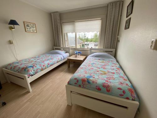 a bedroom with two beds and a window at Huis bij het water in uitstekend fiets-, vis- en vaargebied in Jutrijp