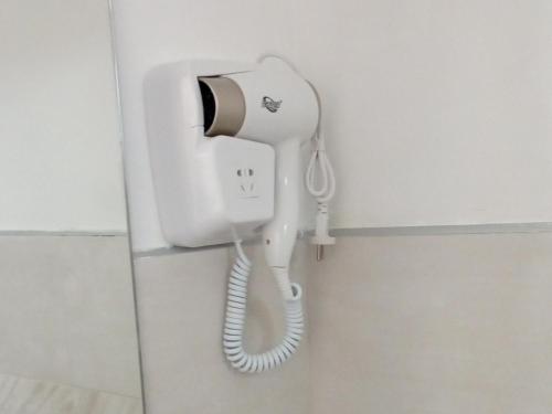 a white phone hanging on a wall in a bathroom at Agrimi b&b in Mesagne