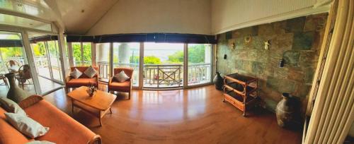 a living room with couches and a stone wall at Beachfront penthouse with panoramic ocean view in Grand Baie