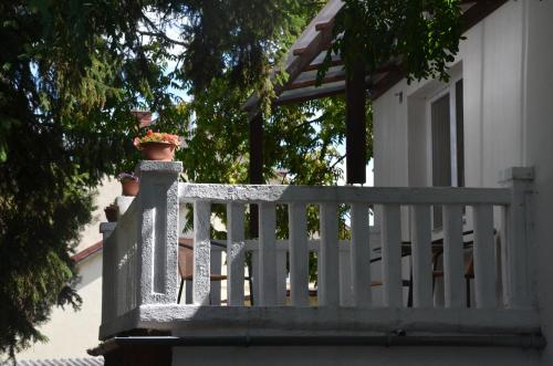 a white fence with two potted plants on it at Hotel Viktória in Balatonalmádi