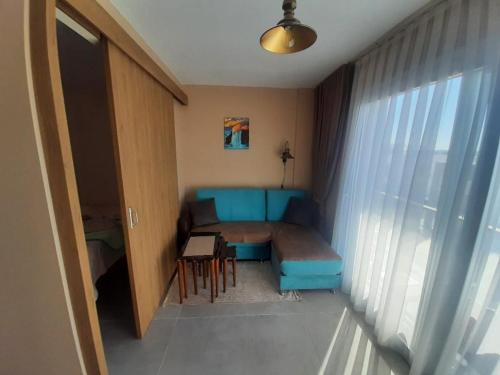 a living room with a blue couch and a table at Дизайнерская студия с отдельной спальней на первой береговой линии Four Seasons Iskele in Iskele