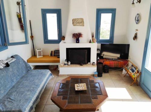 a living room with a couch and a tv at Villa Mariza Kythnos in Kithnos