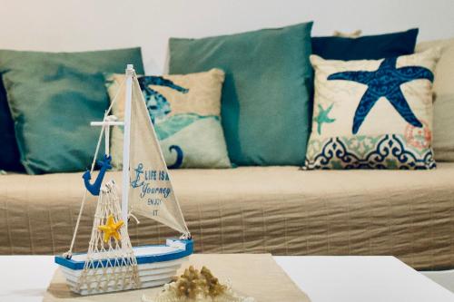 a toy sailboat on a table in front of a couch at Il Mono del Porto - Studio Apartment in Ancona