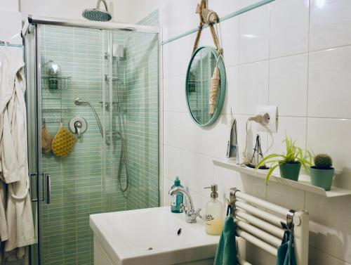a bathroom with a sink and a glass shower at Il Mono del Porto - Studio Apartment in Ancona