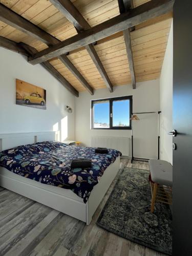 a bedroom with a bed and a wooden ceiling at Black Wood Cabin in Mărişel