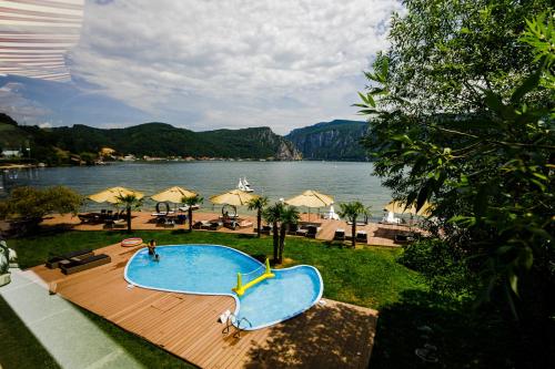a swimming pool with a view of a lake at Pensiunea Decebal Resort - Cazanele Dunarii in Dubova