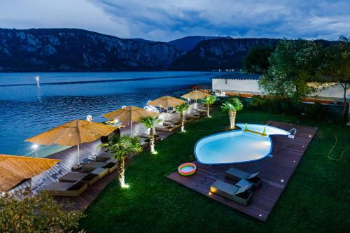 an overhead view of a swimming pool with umbrellas at Pensiunea Decebal Resort - Cazanele Dunarii in Dubova