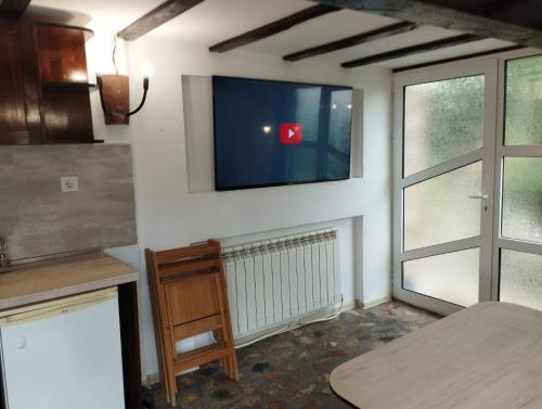 a kitchen with a flat screen tv on the wall at Семейна къща Лазарови in Sapareva Banya