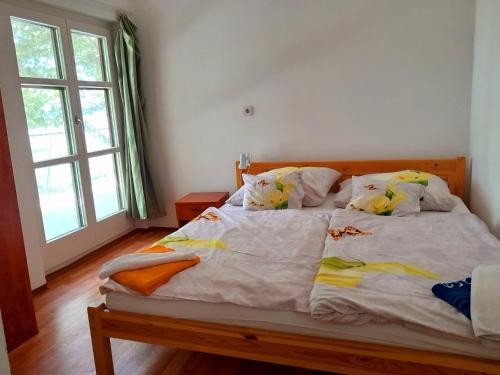 a bedroom with a large bed with yellow pillows at Boglár-Coop Üdülő in Balatonboglár