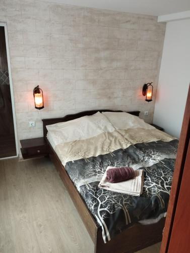 a bed in a room with two lights on it at Семейна къща Лазарови in Sapareva Banya