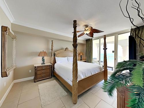 a bedroom with a four poster bed and a fan at Beach Club 904c in Pensacola Beach
