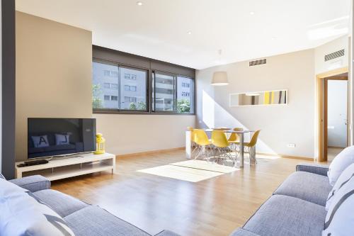 a living room with a couch and a tv and a table at Hotel Acta Laumon in Barcelona
