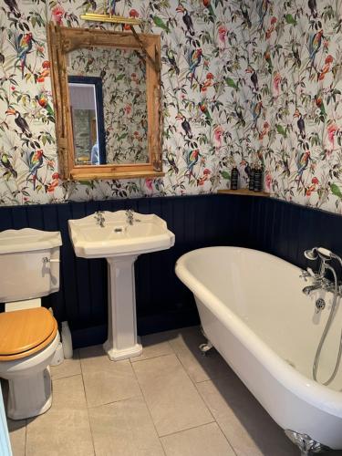 a bathroom with a tub and a toilet and a sink at Century Old Shepherds Cottage overlooking Loch Tay in Aberfeldy