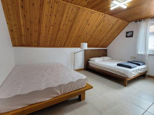 - une chambre avec deux lits et un plafond en bois dans l'établissement Namhae German Village Johannes, à Namhae