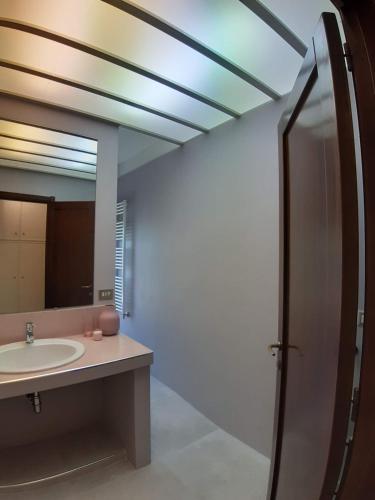 een badkamer met een wastafel en een spiegel bij Bonaria Apartment in Cagliari