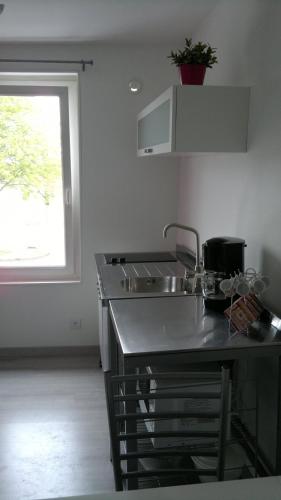 une cuisine avec un évier et une fenêtre dans l'établissement Appartement entre le port et le centre ville de Perros Guirec, à Perros-Guirec