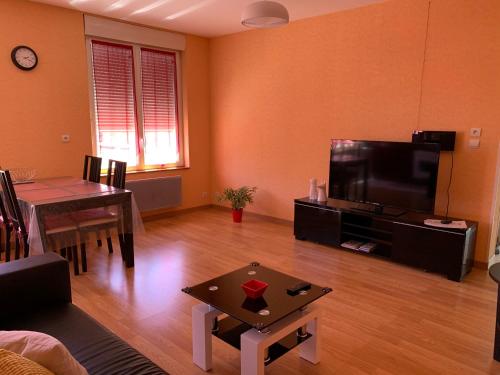 un salon avec une table et une télévision et une salle à manger dans l'établissement RESIDENCE ROKIA - Au fil de l*eau, à Royat