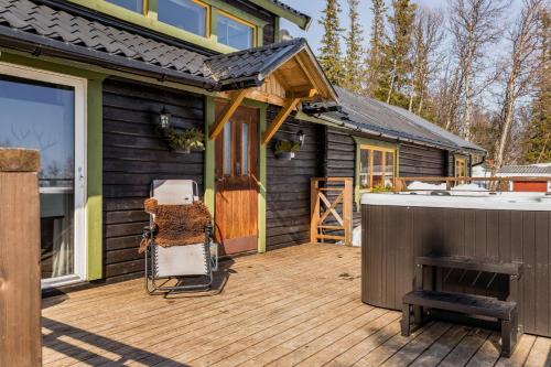 une maison avec une terrasse en bois et une cuisinière dans l'établissement Mysig fjällstuga med direktanslutning till fjället, à Oviken