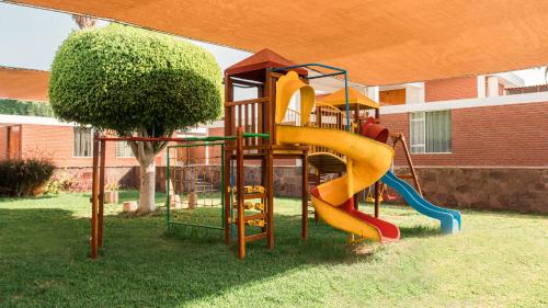 un parque infantil con un tobogán en un patio en Hotel Real Ica, en Ica