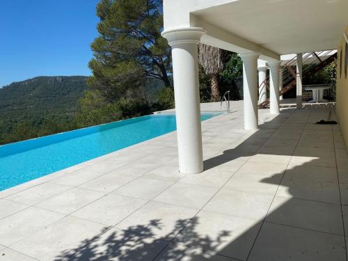 - une vue sur la piscine depuis la terrasse d'une maison dans l'établissement Villa d'Eden domaineleshesperides, à Bagnols-en-Forêt