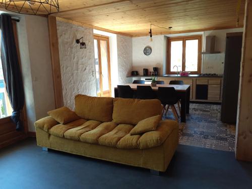 a living room with a couch and a kitchen at Tres bel appartement dans une maison avec SPA in Séez