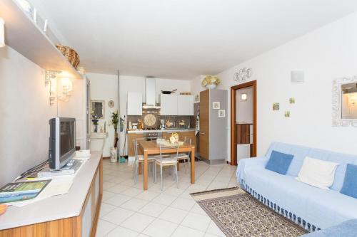 a living room with a blue couch and a kitchen at La Casa Di Federica in Corciano