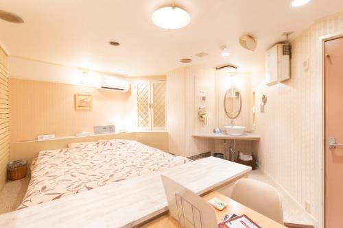een slaapkamer met een groot bed en een wastafel bij ファインリゾート in Nagoya