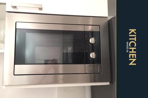 a stainless steel microwave oven in a kitchen at 3 BR Stylish Condo with Private Rooftop Pool in Kamala Beach