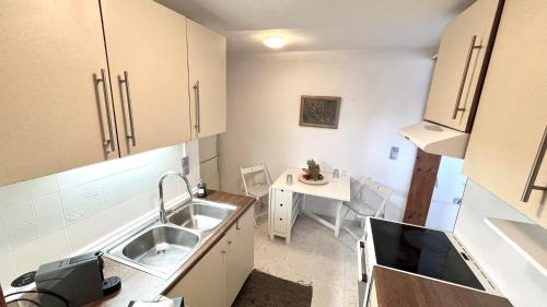 a small kitchen with a sink and a table at Su Casa KEA in Korissia