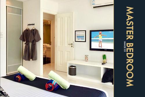 a bedroom with a bed and a tv in a room at 3 BR Stylish Condo with Private Rooftop Pool in Kamala Beach
