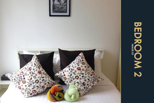 a bed with pillows and stuffed animals on it at 3 BR Stylish Condo with Private Rooftop Pool in Kamala Beach