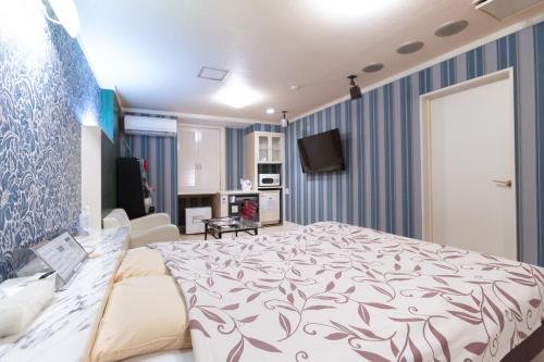 a bedroom with a bed and a living room at ファインリゾート in Nagoya