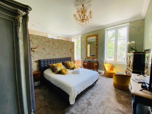 a bedroom with a bed and a chandelier at Château Bois-Martin in Léognan