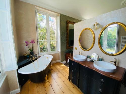 a bathroom with two sinks and a large mirror at Château Bois-Martin in Léognan