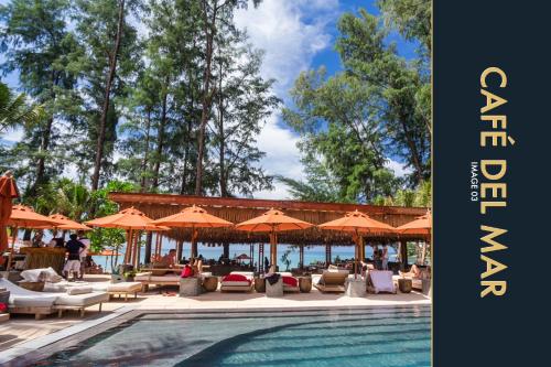 a swimming pool with umbrellas and lounge chairs and a swimming pool at 3 BR Stylish Condo with Private Rooftop Pool in Kamala Beach