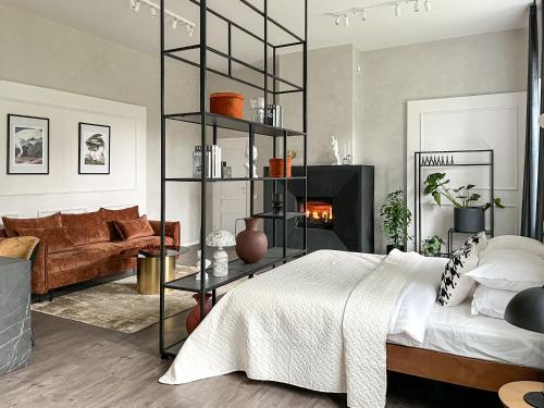 a bedroom with a bed and a fireplace at Kamurke - Apartamentai in Šiauliai