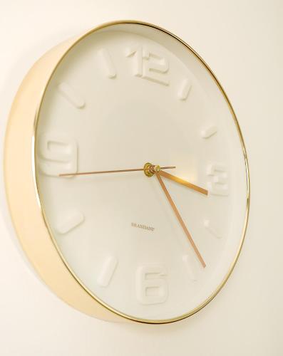 a gold and white clock on a white background at A casarella in piazzetta in Capri
