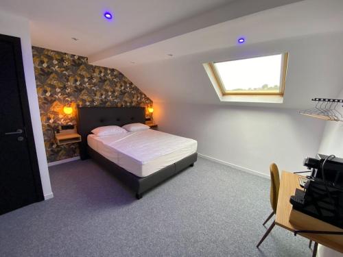 sypialnia z dużym łóżkiem i oknem w obiekcie BED Cauchy w mieście Namur