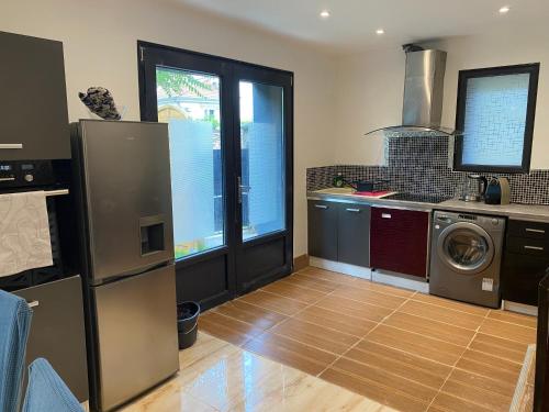 eine Küche mit Kühlschrank und Waschmaschine in der Unterkunft Joli duplex climatisé à 30min Paris in Montmorency
