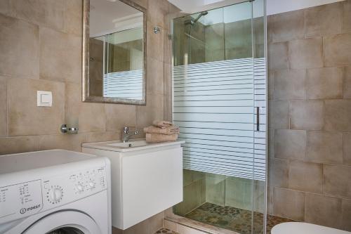 uma casa de banho com uma máquina de lavar roupa e um chuveiro em Julia's Boutique Suites, near Argostoli. em Travliáta
