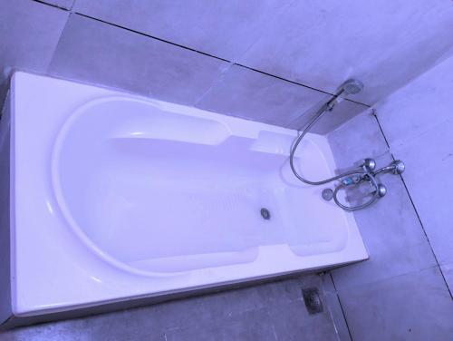 e bagno con vasca bianca e doccia. di Hotel Neptune Palace ad Ānand