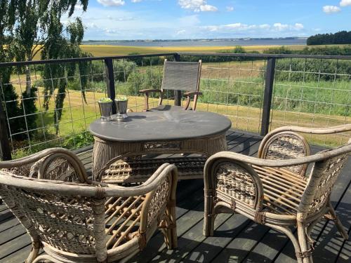 a table and two chairs on a deck with a view at Den Gamle Apotekergaard in Høng