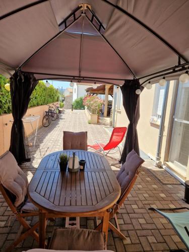 a table and chairs under a tent on a patio at Apartments Glibo in Cres