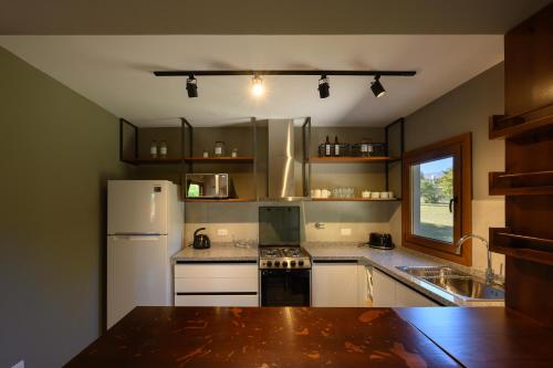 a kitchen with a white refrigerator and a sink at Casas Acrux in Nono