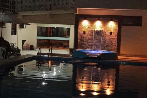 a swimming pool with a fountain in the middle at Pousada Villa Goyá in São José da Coroa Grande