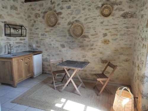 a kitchen with a table and chairs and a sink at mas de raynal in Balaguier-dʼOlt