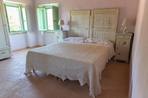 a bedroom with a bed and two dressers and windows at Il casale dei nonni in Grottazzolina