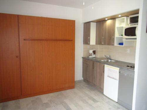 - une cuisine avec une porte en bois et un évier dans l'établissement Vacances au soleil à HYERES 25m2 avec balcon, à Hyères