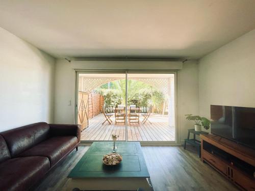 un salon avec un canapé et une table dans l'établissement LANTON PLAGE - APPARTEMENT 6 PERS. TERRASSE, à Lanton