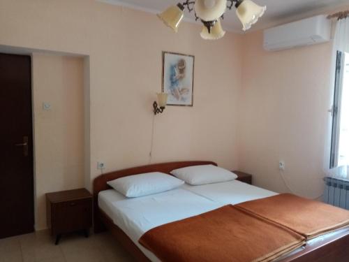 sypialnia z łóżkiem i żyrandolem w obiekcie Rooms MUDRAC w mieście Senj